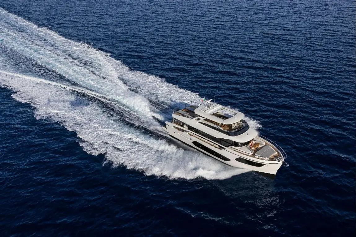 A modern yacht cruising over deep blue waters, creating white wake trails in the sea. Ideal for luxury marine experiences.